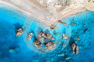 Aerial view of blue sea, rocks in clear water, white sandy beach