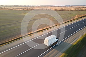 Aerial view of blurred fast moving cargo van driving on highway hauling goods. Delivery transportation and logistics