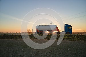 Aerial view of blurred fast moving cement cargo truck driving on highway hauling goods. Delivery transportation and