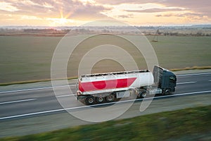 Aerial view of blurred fast moving fuel cargo truck driving on highway hauling goods. Delivery transportation and