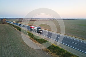 Aerial view of blurred fast moving fuel cargo truck driving on highway hauling goods. Delivery transportation and