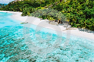 Aerial view of boat moored at uninhabitable island with tropical beautiful azure blue lagoon, Seychelles