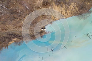 Aerial view of a boat in a turquoise lake contaminated with cyanide