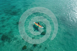 Aerial view of a boat on the turquoise sea. Aerial view of a woman on a surfboard in the turquoise waters of the Maldives, AI