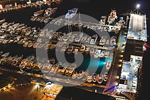 Aerial view of boats and beautiful city at night in Sorrento, Italy. Amazing landscape with boats in marina bay, sea, city lights