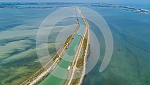 Aerial view of boats in canal in lagoon of Mediterranean sea Etang de Thau water from above, travel by barge in France