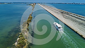 Aerial view of boats in canal in lagoon of Mediterranean sea Etang de Thau water from above, travel by barge in France