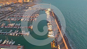 Aerial view of boats in the harbor, with city buildings behind