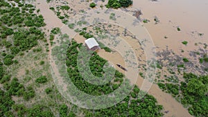 Aerial view of boats and houses flooded in rural Thailand. Top view of the river flowing after heavy rain and flooding in the vill