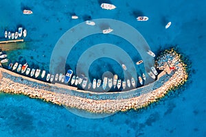 Aerial view of boats and yachts in dock, breakwater and blue sea