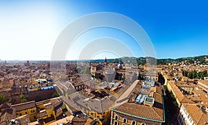 Aerial view of Bologna, Italy at sunset. Colorful sky over the historical city center with car traffic and old buildings roofs.