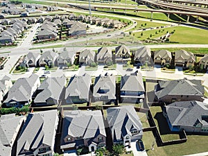 Aerial view brand new large two story houses near highway with stack interchange system in North Texas, US