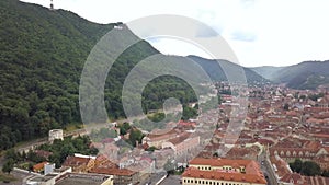 Aerial view of Brasov city, medieval town situated in Transylvania, Romania. Old architecture surrounded with big Carpathian mount