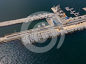 Aerial view of breakwater construction. Crane on a pile of boulders in the sea