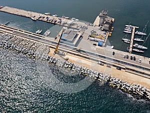 Aerial view of breakwater construction. Crane on a pile of boulders in the sea