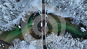 Aerial view of bridge and beautiful river in snowy forest