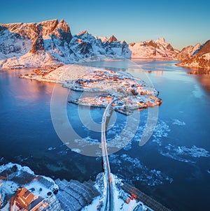 Aerial view of bridge over the sea and snowy mountains in Norway