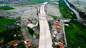 Aerial view. Bridge under construction and the edge of an urban river with houses