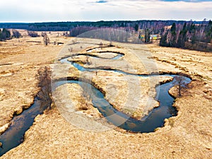 Aerial view of brook bends in spring medow. Belarus