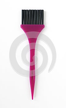 Aerial view of brush with black bristles and pink handle in vertical position. Close up of hair dye brush made with recyclable