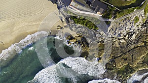 Aerial view of building at edge of beach rock ledge