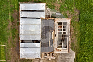 Aerial view of building site for future brick house, concrete foundation floor and stacks of yellow clay bricks for construction