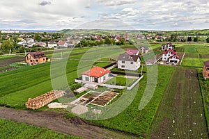 Aerial view of building site for future brick house, concrete foundation floor and stacks of yellow clay bricks for construction