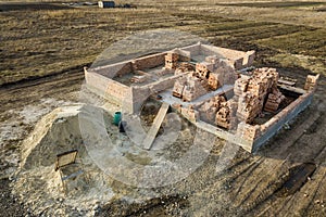 Aerial view of building site. Trenches dug in ground and filled with cement as foundation for future house, brick basement floor