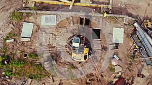 Aerial view of a building site. Yellow construction machine left in the middle. New highway.