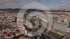 Aerial view of buildings in urban boroughs along river. Busy roads on waterfronts. Metropolis at golden hour. Vienna