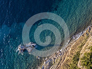 Aerial view of Buljarica promontory, steep cliff on the coast lapped by Adriatic sea. Petrovac, Montenegro photo