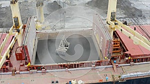 Aerial view of bulk-carrier ship docked loading minerals in port.