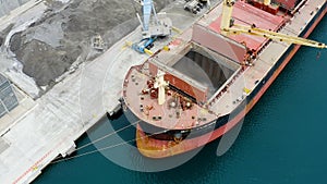 Aerial view of bulk-carrier ship docked loading minerals in port. photo