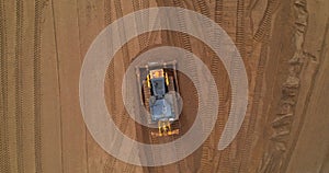 Aerial view of a bulldozer leveling the ground on a construction site