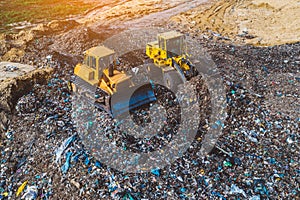 Aerial view on bulldozers working on the landfill.