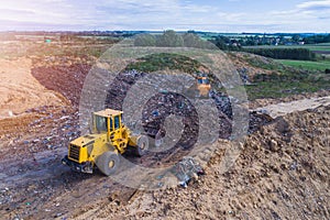 Aerial view on bulldozers working on the landfill.