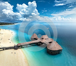 Aerial view of bungalow, white sandy beach, sea and palms photo