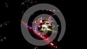 Aerial view of a burning house with emergency vehicles and siren lights at night