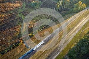Aerial view of busy american freeway with fast moving cars and trucks. Interstate hauling of goods concept