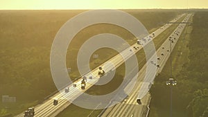 Aerial view of busy american highway with fast moving traffic at sunset. Interstate transportation concept