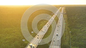 Aerial view of busy american highway with fast moving traffic at sunset. Interstate transportation concept