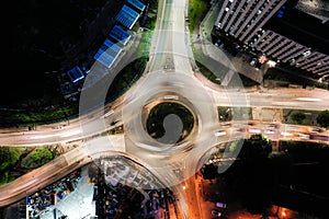 Aerial view of a busy city roundabout street at night rush hour