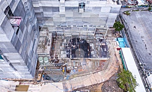 Aerial view of busy industrial construction site workers with cranes working. Top view of development high rise architecture