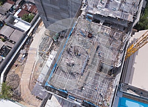Aerial view of busy industrial construction site workers with cranes working. Top view of development high rise architecture