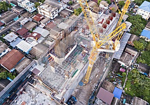 Aerial view of busy industrial construction site workers with cranes working. Top view of development high rise architecture