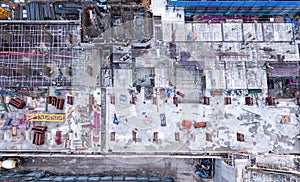 Aerial view of busy industrial construction site workers with cranes working. Top view of development high rise architecture