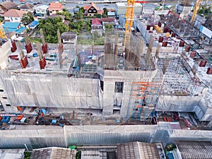 Aerial view of busy industrial construction site workers with cranes working. Top view of development high rise architecture