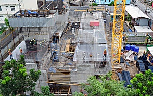 Aerial view of busy industrial construction site workers with cranes working. Top view of development high rise architecture