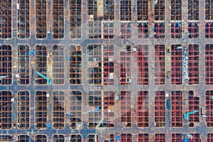 Aerial view of busy industrial under construction site workers working with cranes and excavators. Top view of precast concrete