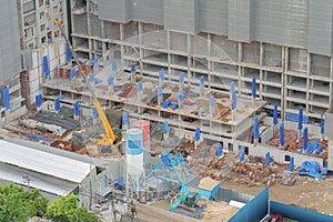 Aerial view of busy industrial under construction site workers working with cranes and excavators. Top view of precast concrete